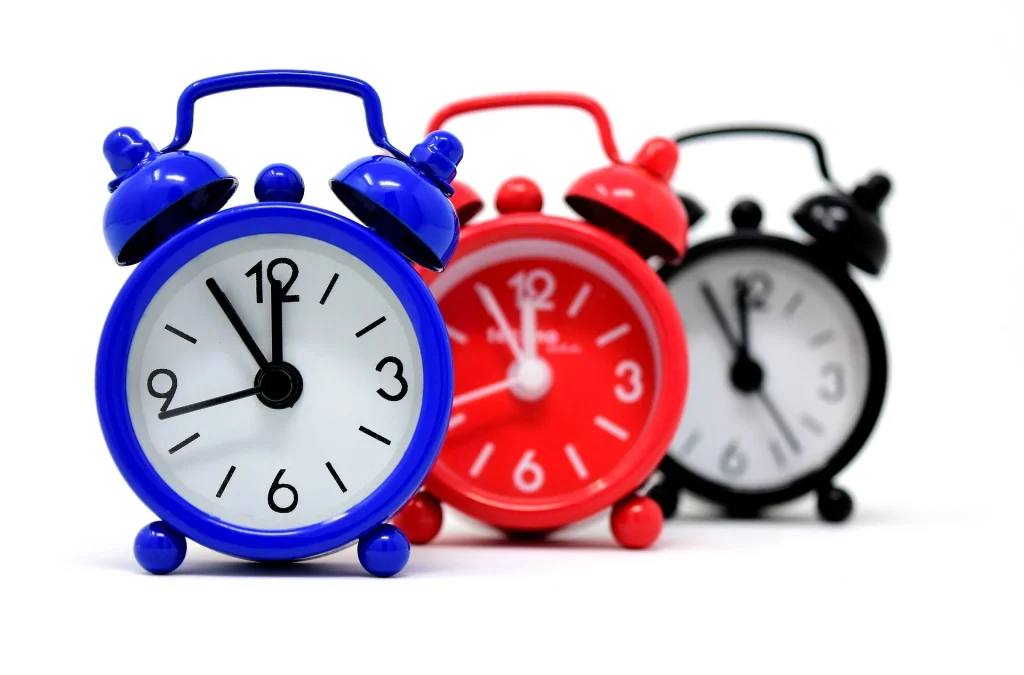 Three alarm clocks, one blue, red and black